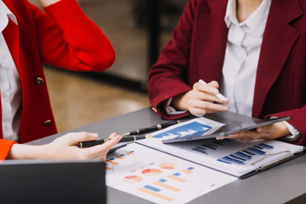 Coworkers analyzing business data and charts together, representing teamwork and data-driven decision-making.